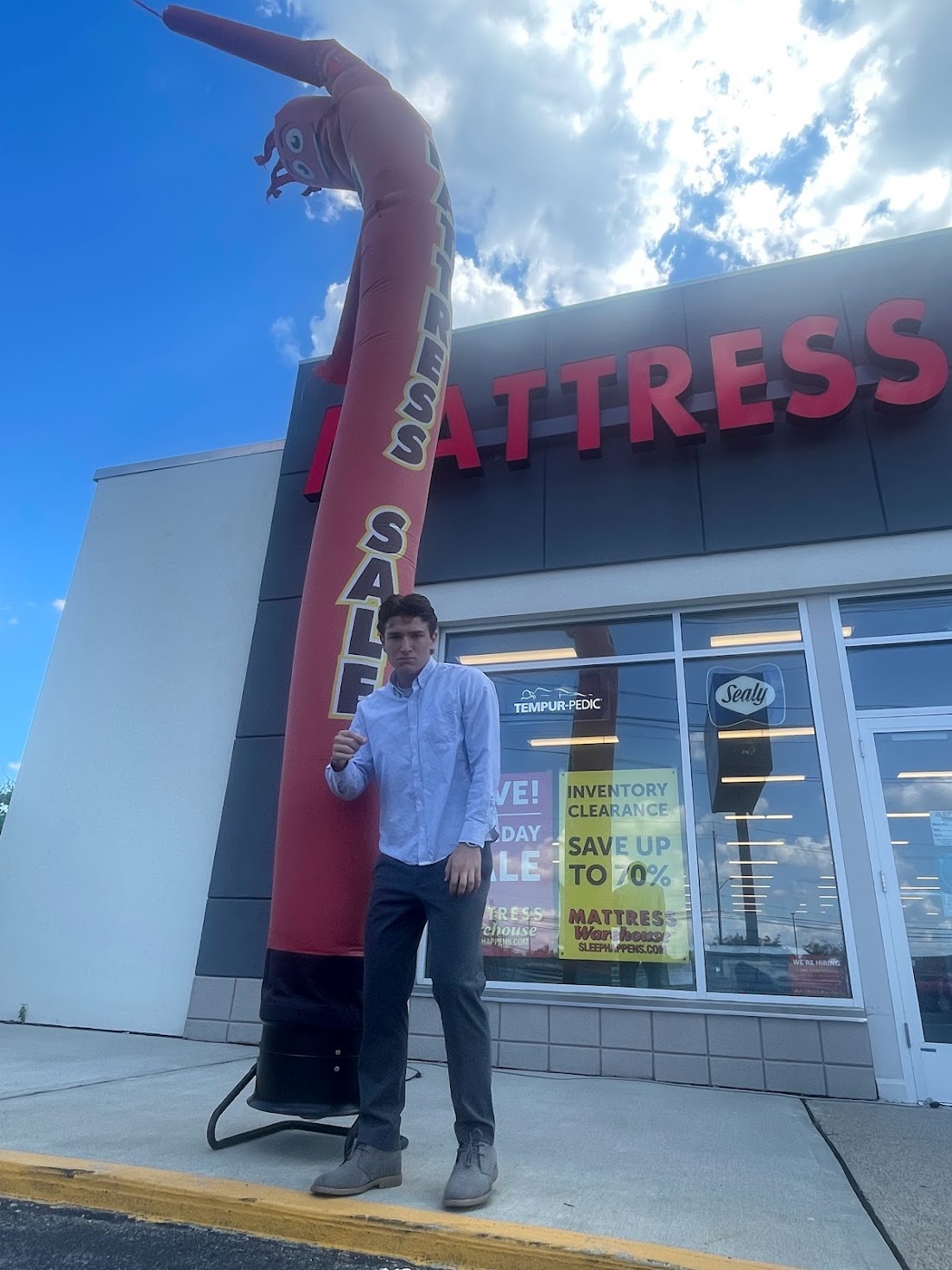 Dale outside Mattress Warehouse in Montclair with an inflatable sale figure